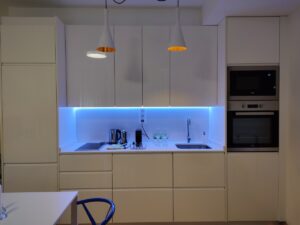 Vista de la cocina integrada en el salón, con iluminación led altamente decorativa